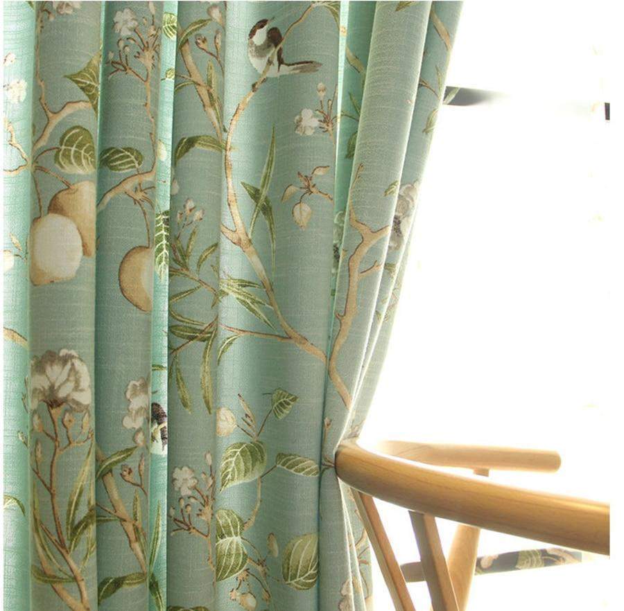 Cortinas opacas azules con estampados florales de pájaros.