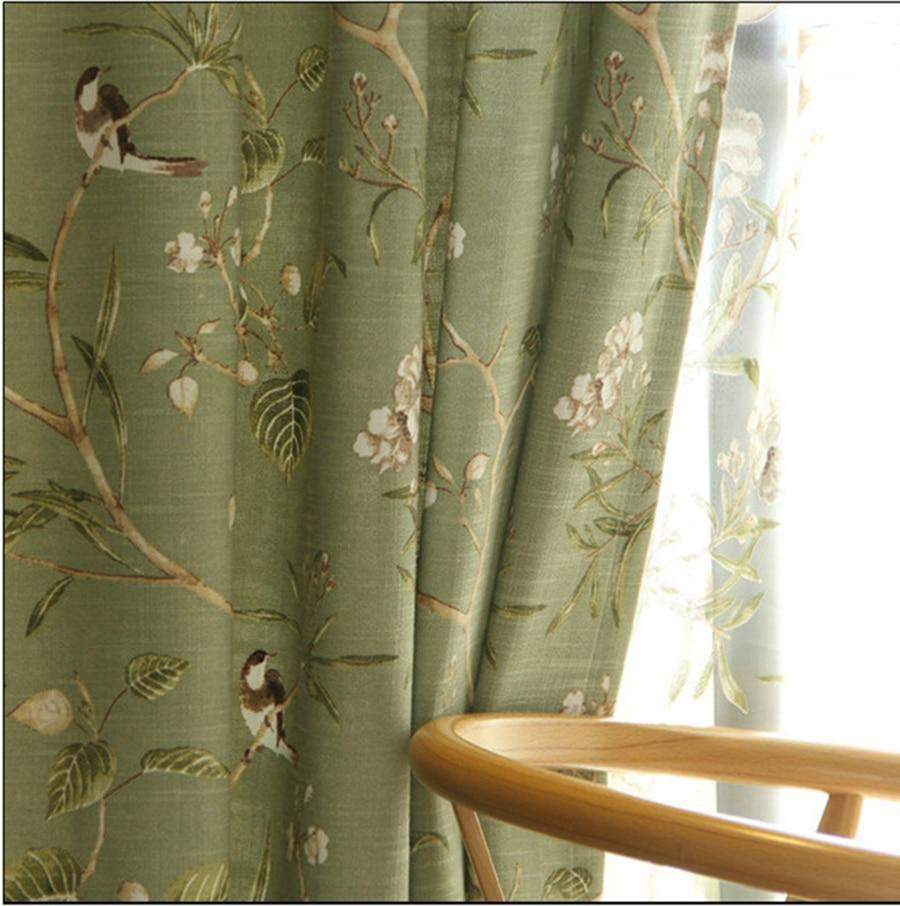 Cortinas opacas verdes con estampados florales de pájaros.