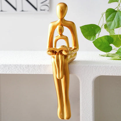 Goldene Harzskulptur „Eltern-Kind beim Lesen“