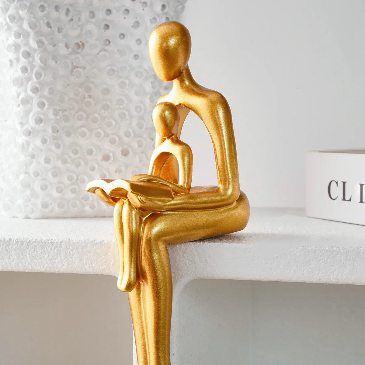 Goldene Harzskulptur „Eltern-Kind beim Lesen“