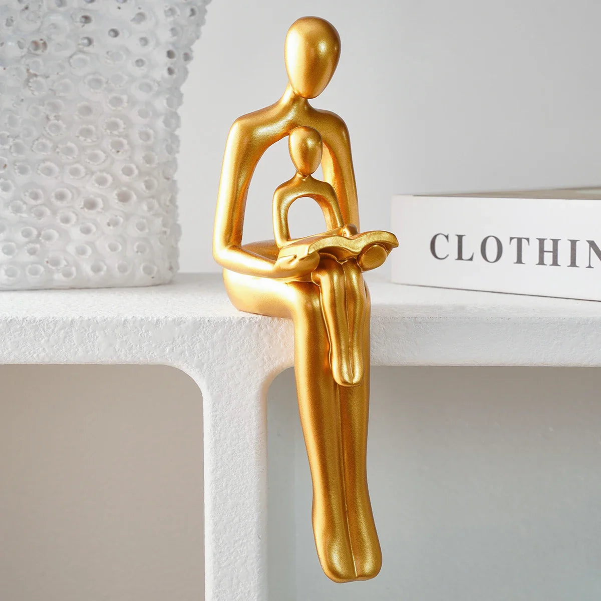 Goldene Harzskulptur „Eltern-Kind beim Lesen“