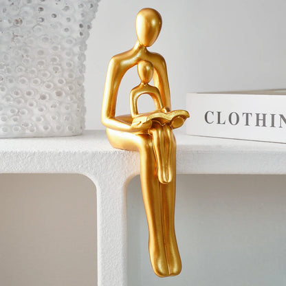 Goldene Harzskulptur „Eltern-Kind beim Lesen“