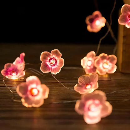 Lichterkette mit kleinen rosa Blumen