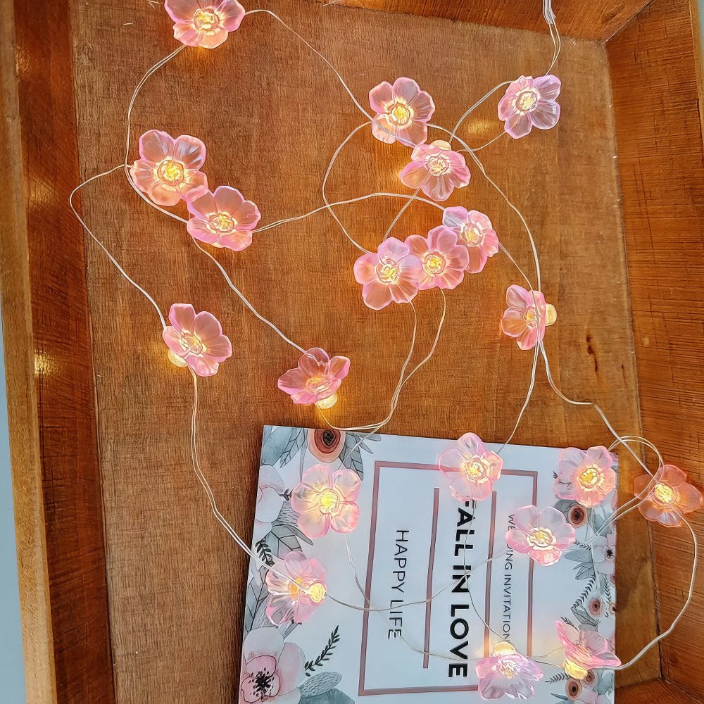 Lichterkette mit kleinen rosa Blumen