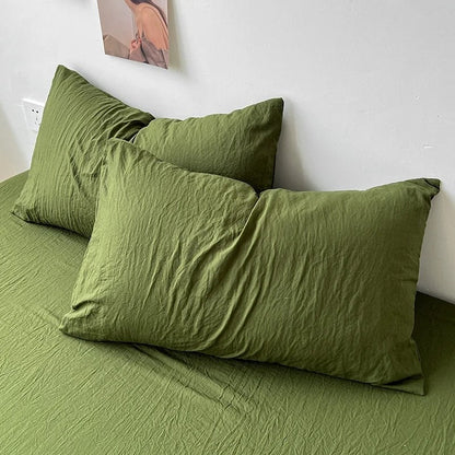 Juego de cama con sábanas arrugadas de colores lisos